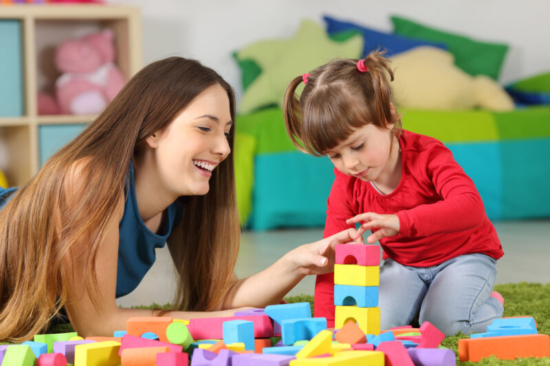 Frau spielt mit Kleinkind