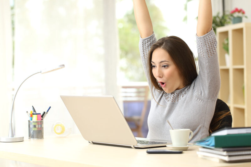 Frau vor dem Computer glücklich