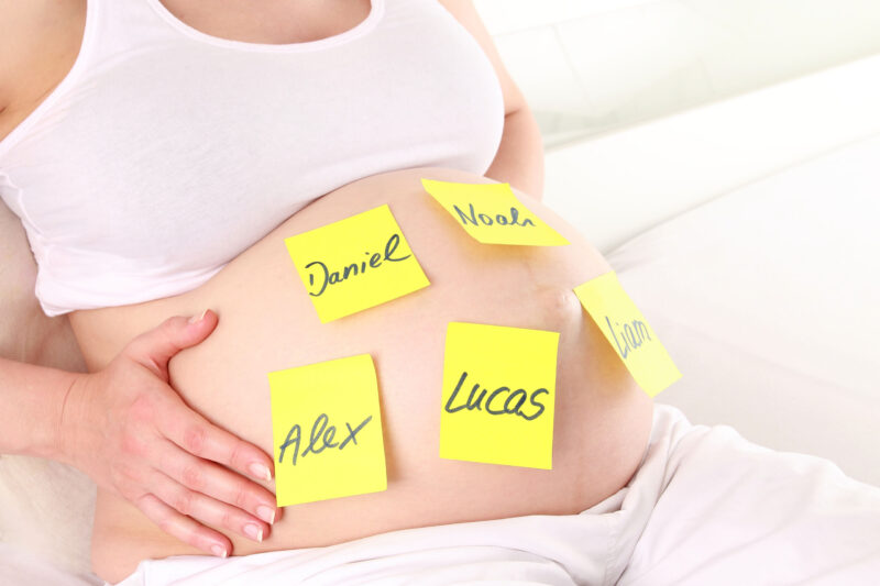Schwangerschaftsbauch mit Namenskärtchen