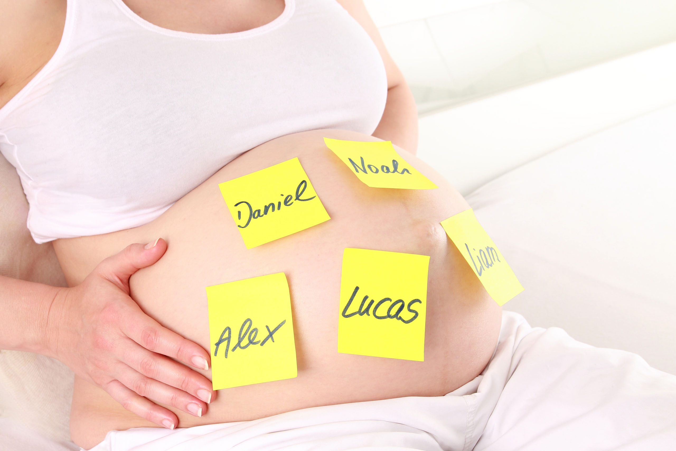 Schwangerschaftsbauch mit Namenskärtchen
