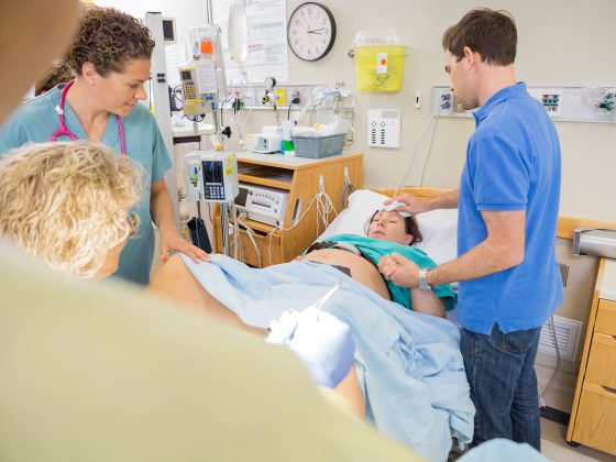 Vater begleitet Muter bei der Geburt